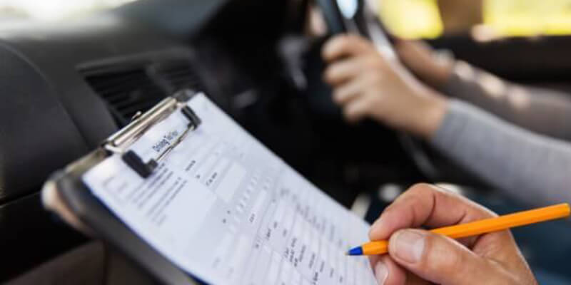Examiner marking the driving test marking sheet