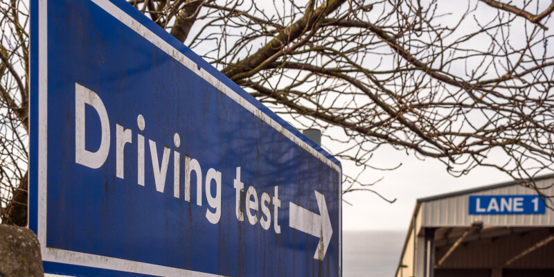 Blue sign with arrow with the words: driving test