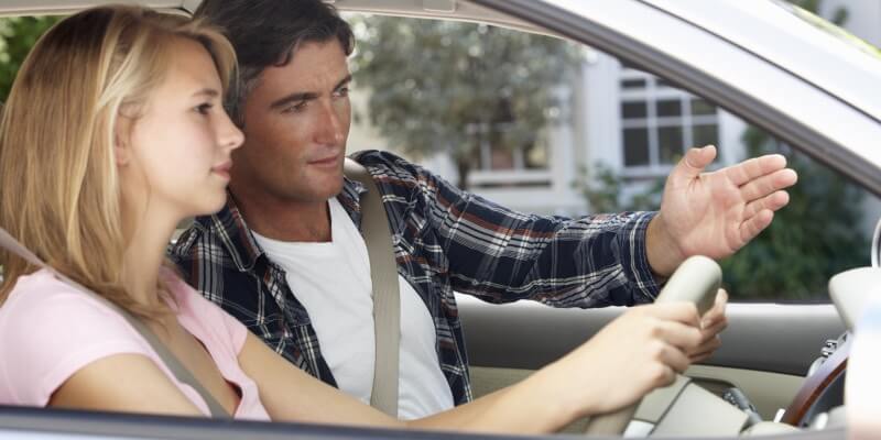 Man in car with girl gesturing ahead