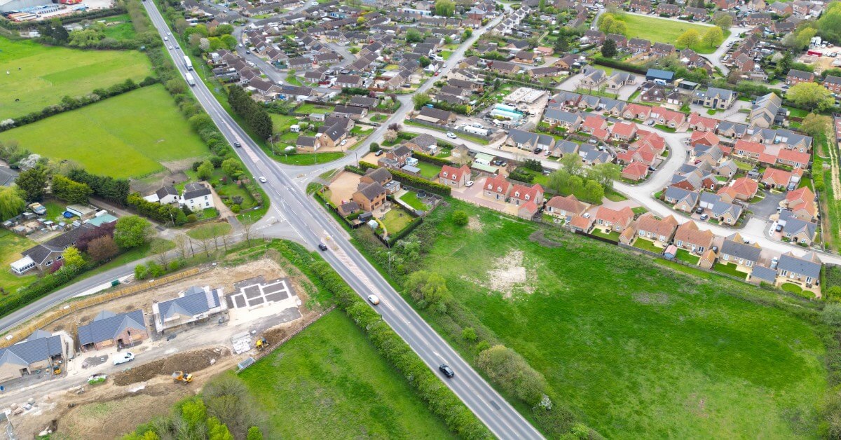 Aerial view of a crossroad amongst houses and fields