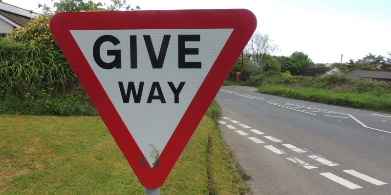 UK give way sign with empty road in background