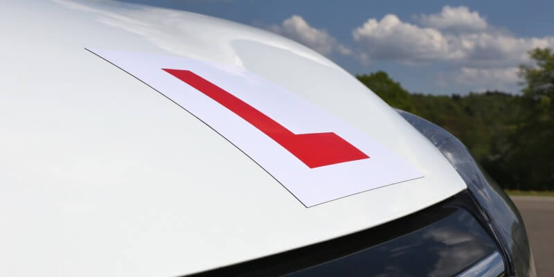 White bonnet of car with l-plate stuck on