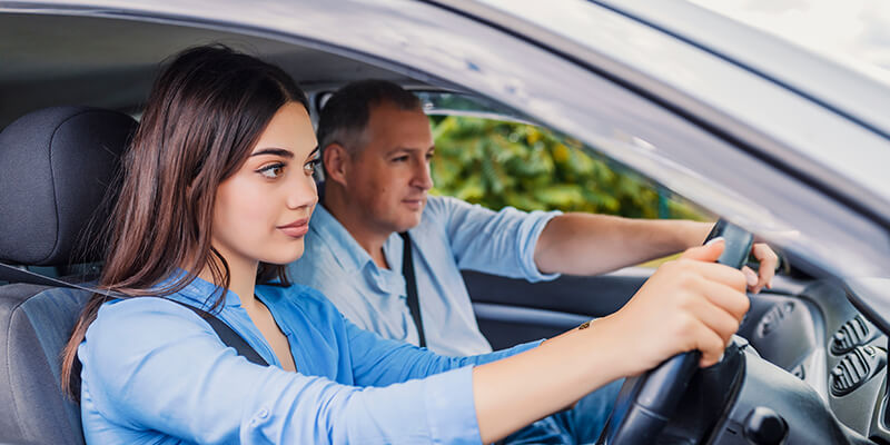 Instructor guiding learner on what to do inside car
